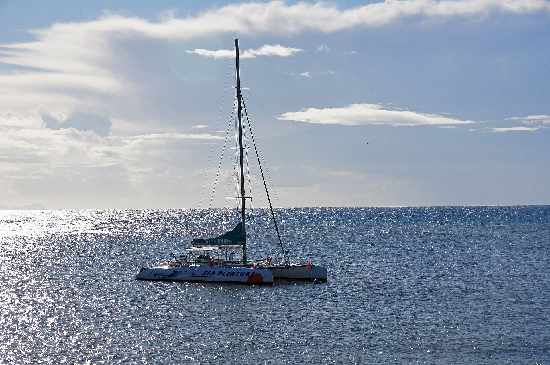 A catamaran drifting on deep, sparkling Atlantic water off Funchal, Madeira